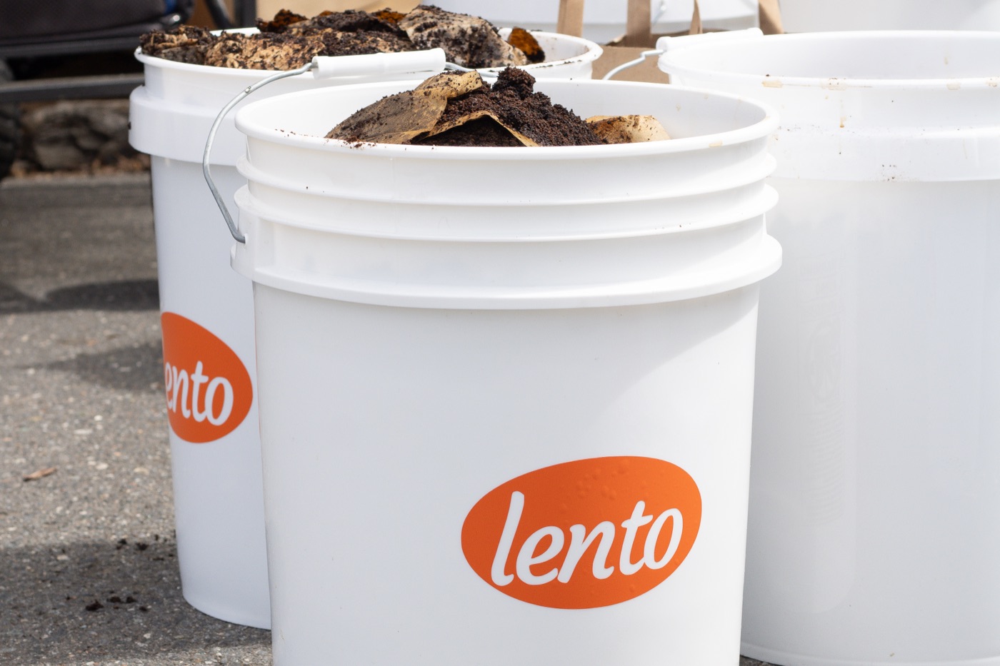 White lento buckets full of coffee grounds and cardboard